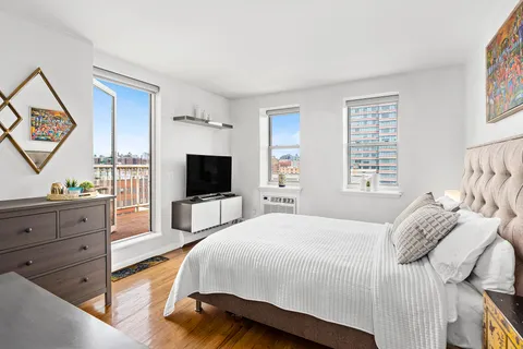 a spacious bedroom with a bed and a flat screen tv