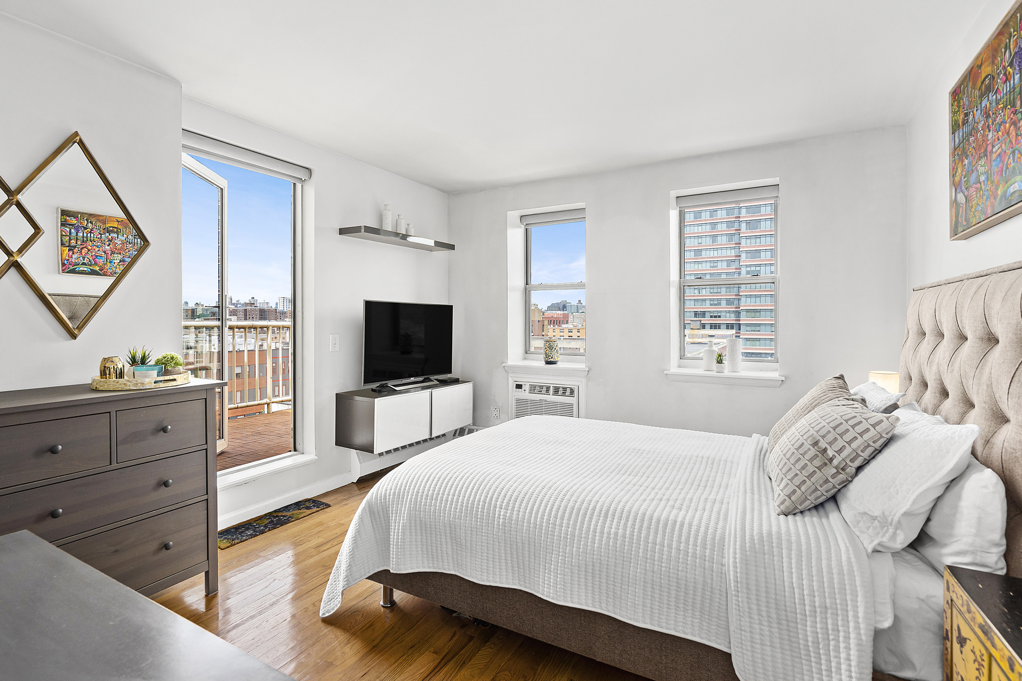 1831 Madison Avenue, Unit 9E Manhattan, NY 10035 - Photo 6 of 18 a spacious bedroom with a bed and a flat screen tv