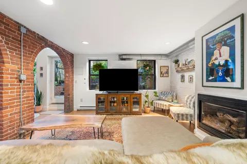 a living room with furniture a flat screen tv and a fireplace