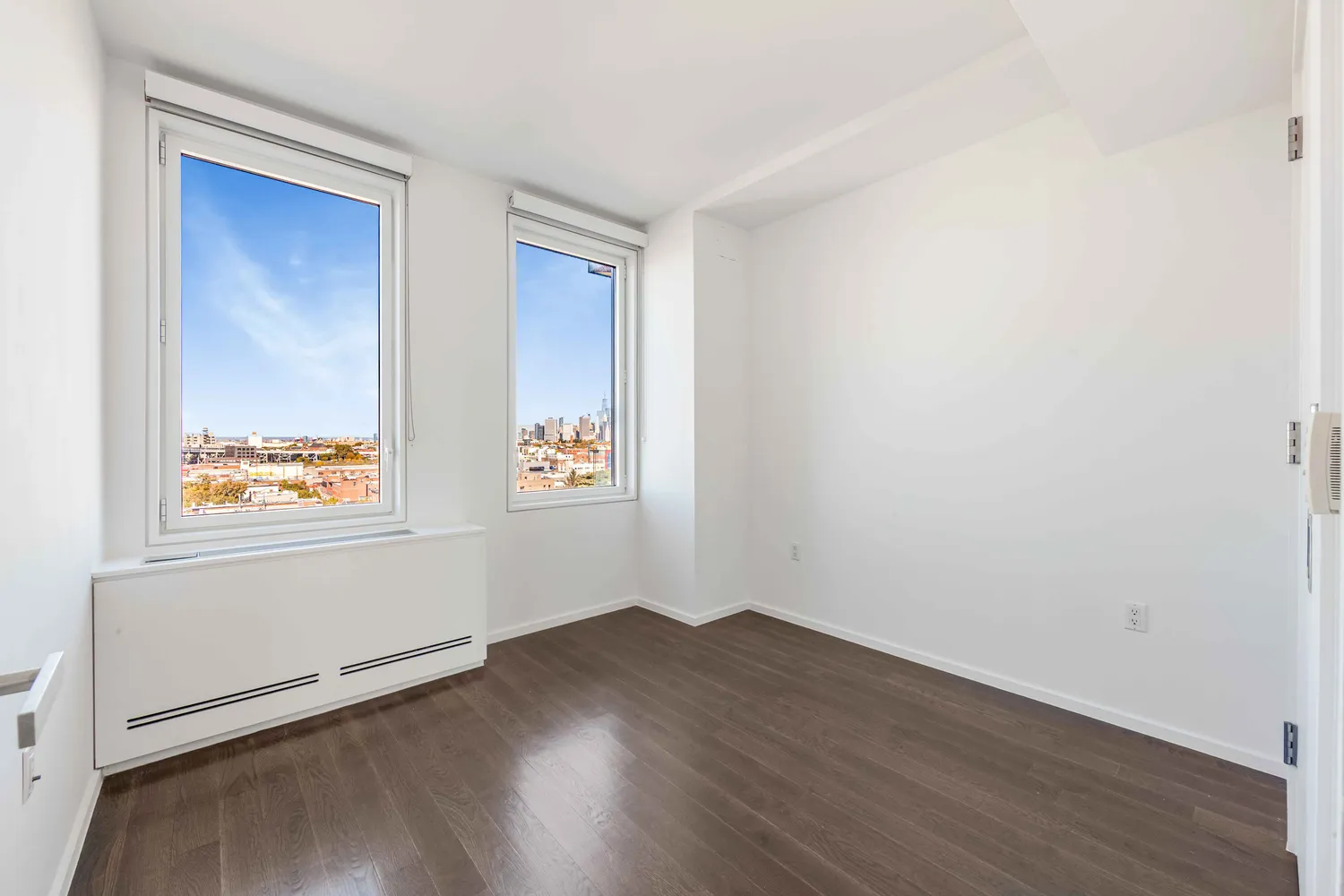 an empty room with wooden floor and window