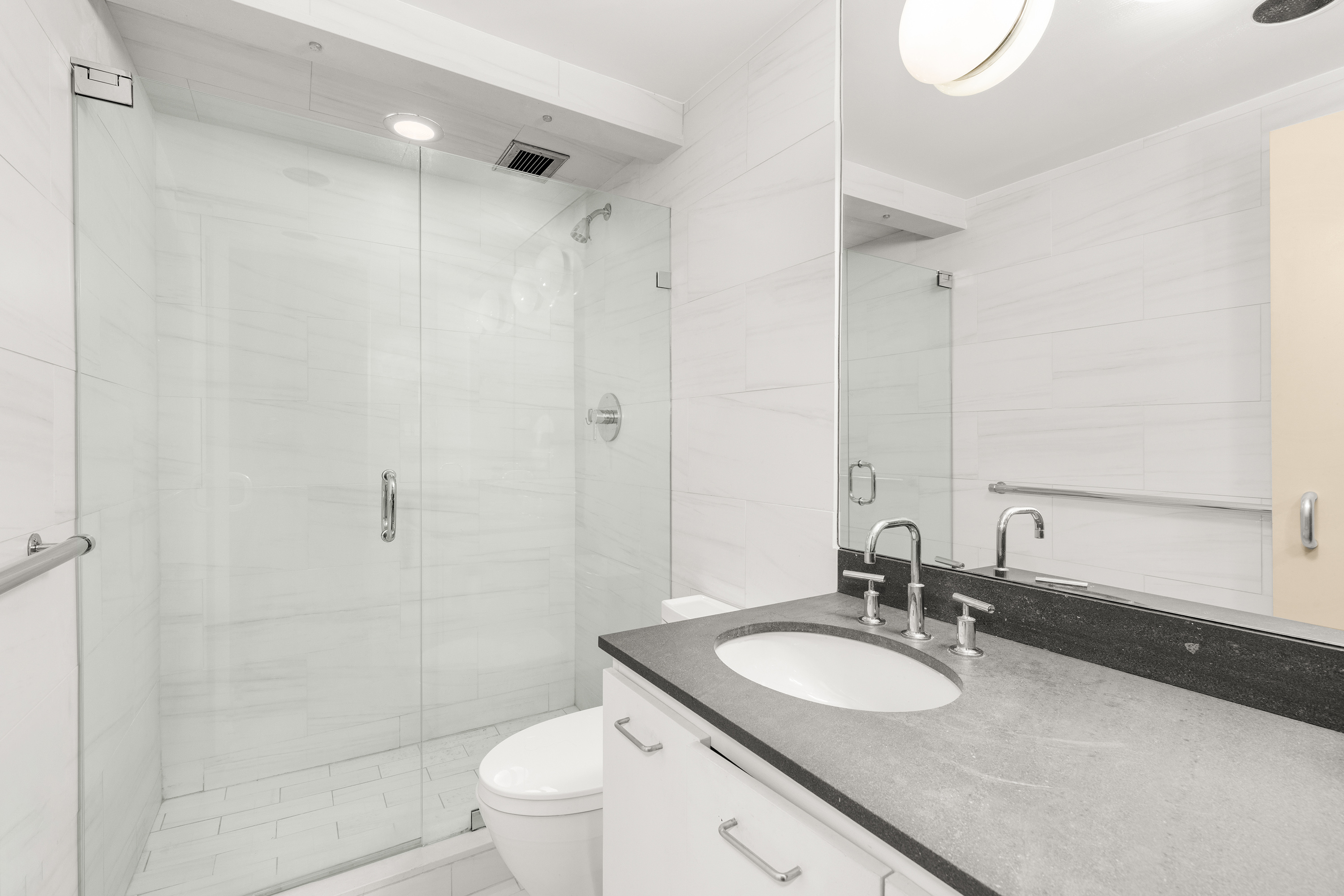 860 United Nations Plaza, Unit 36D Manhattan, NY 10017 - Photo 12 of 21 a bathroom with a granite countertop sink toilet mirror and shower