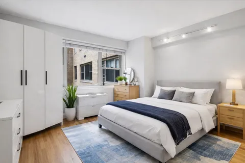 a bedroom with a bed and a potted plant