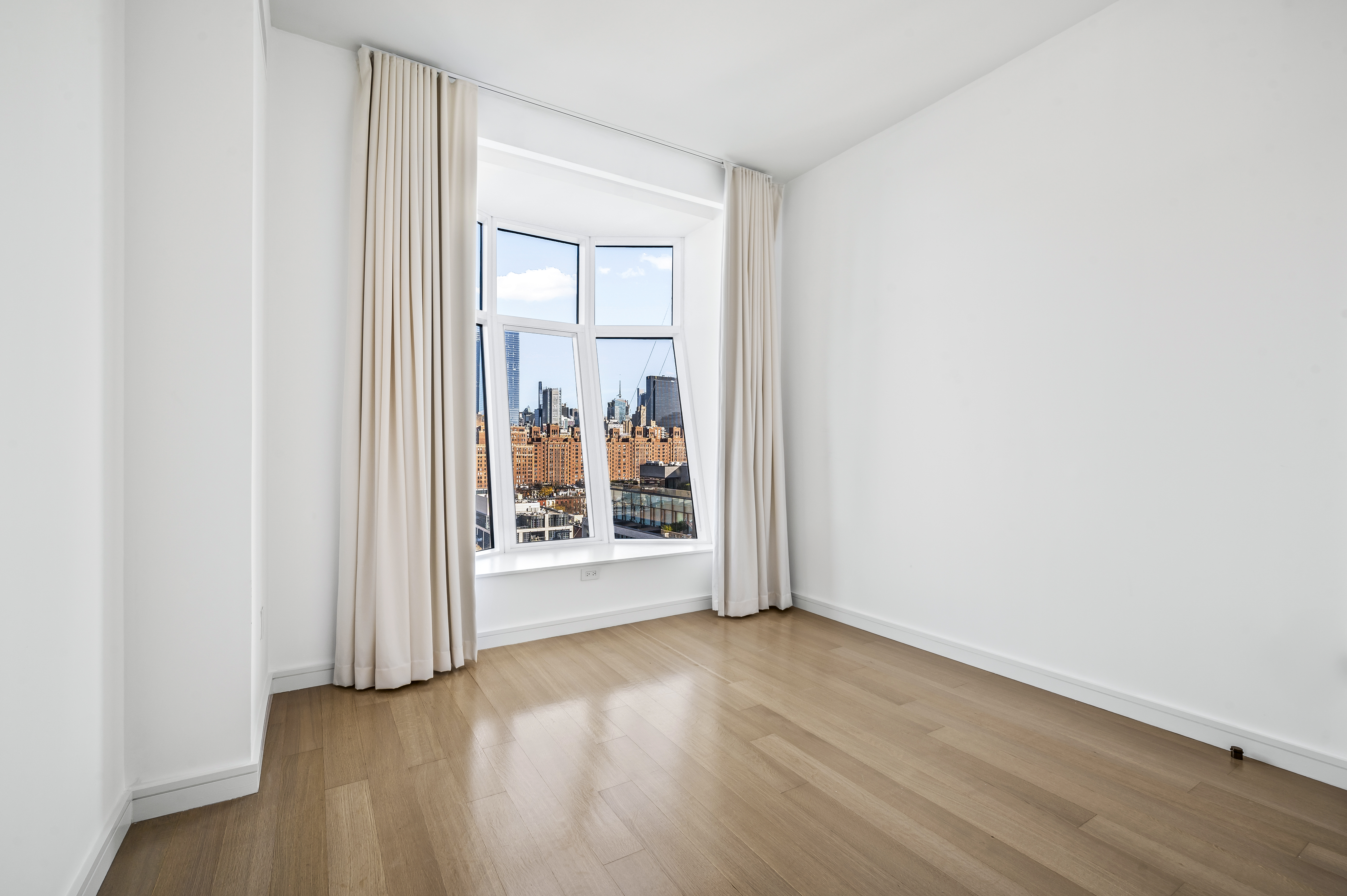 515 West 18th Street, Unit 1401 Manhattan, NY 10011 - Photo 5 of 12 an empty room with wooden floor and a window