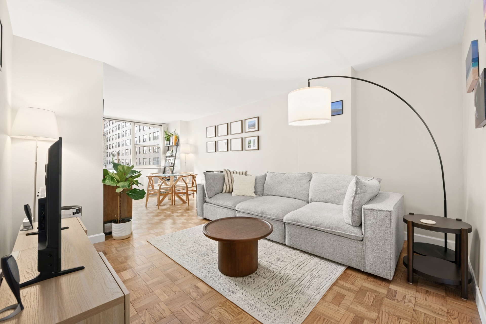 200 East 58th Street, Unit 10J Manhattan, NY 10022 - Photo 1 of 8 a living room with furniture a couch and a potted plant