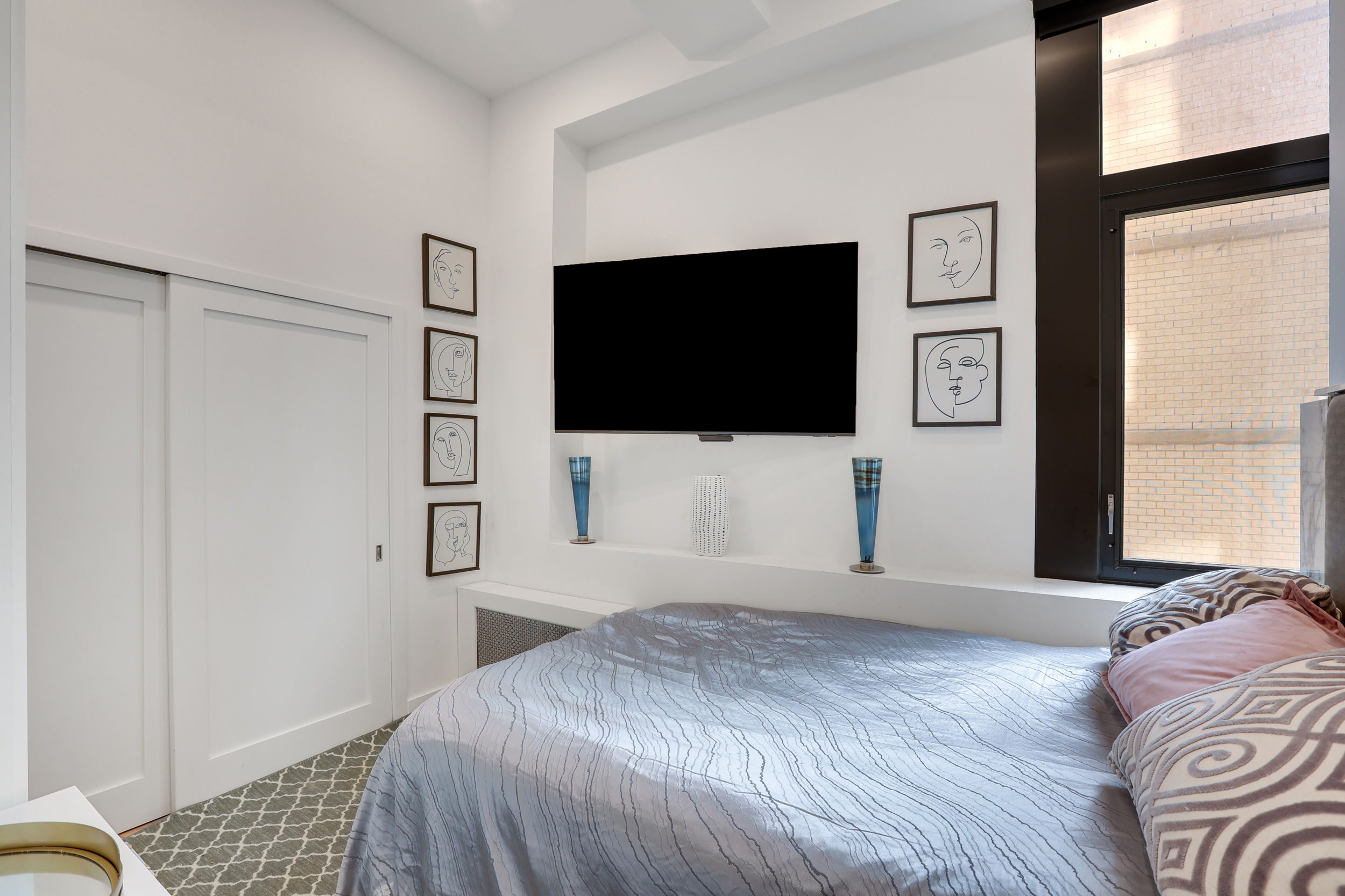 310 East 46th Street, Unit 20H Manhattan, NY 10017 - Photo 8 of 9 a bedroom with a bed and a flat screen tv