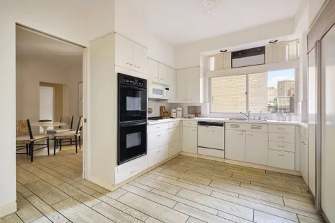 a kitchen with white cabinets and appliances
