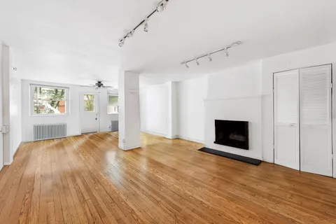 a view of empty room with wooden floor and fireplace