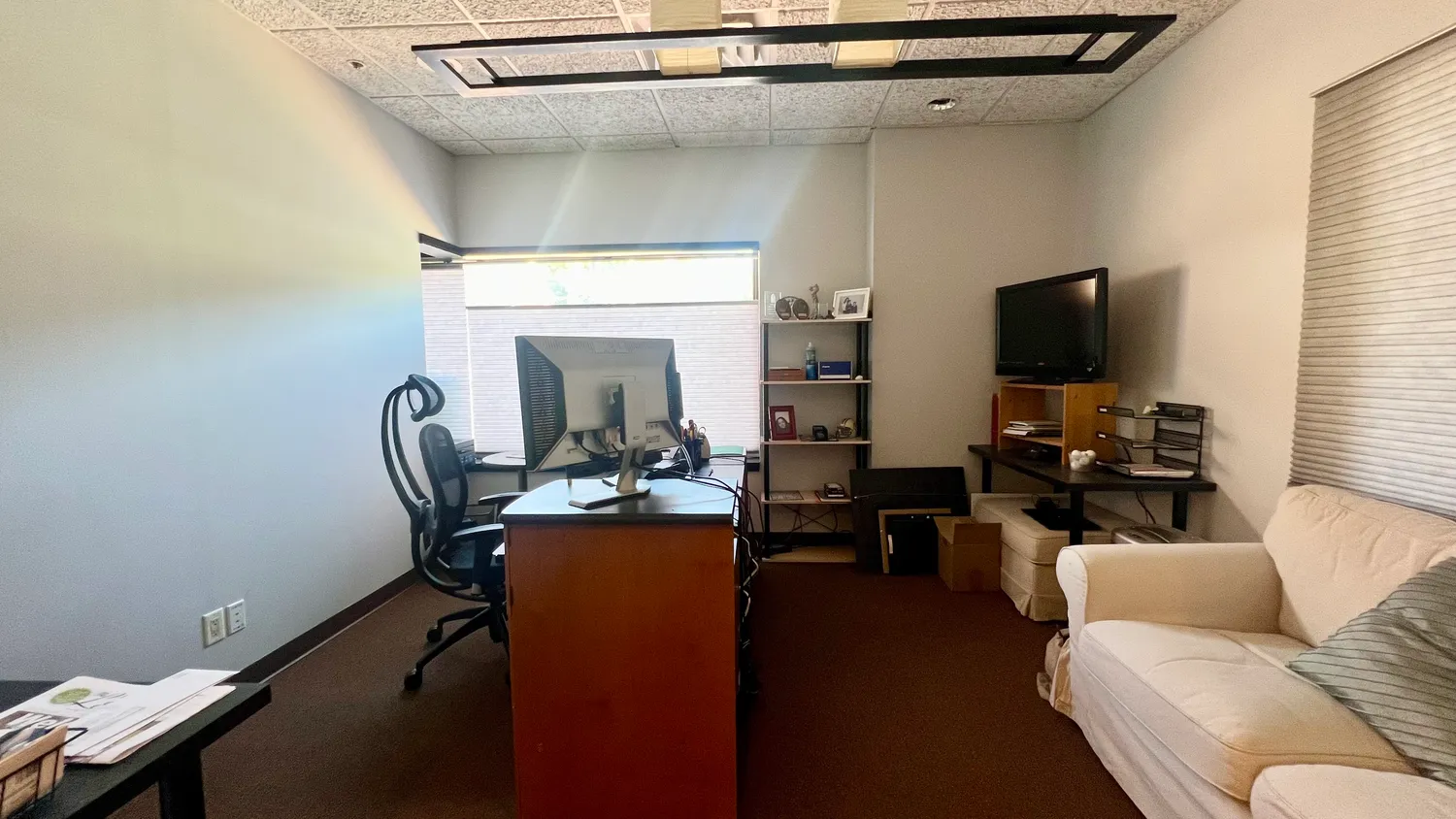 a living room with furniture a flat screen tv and a window