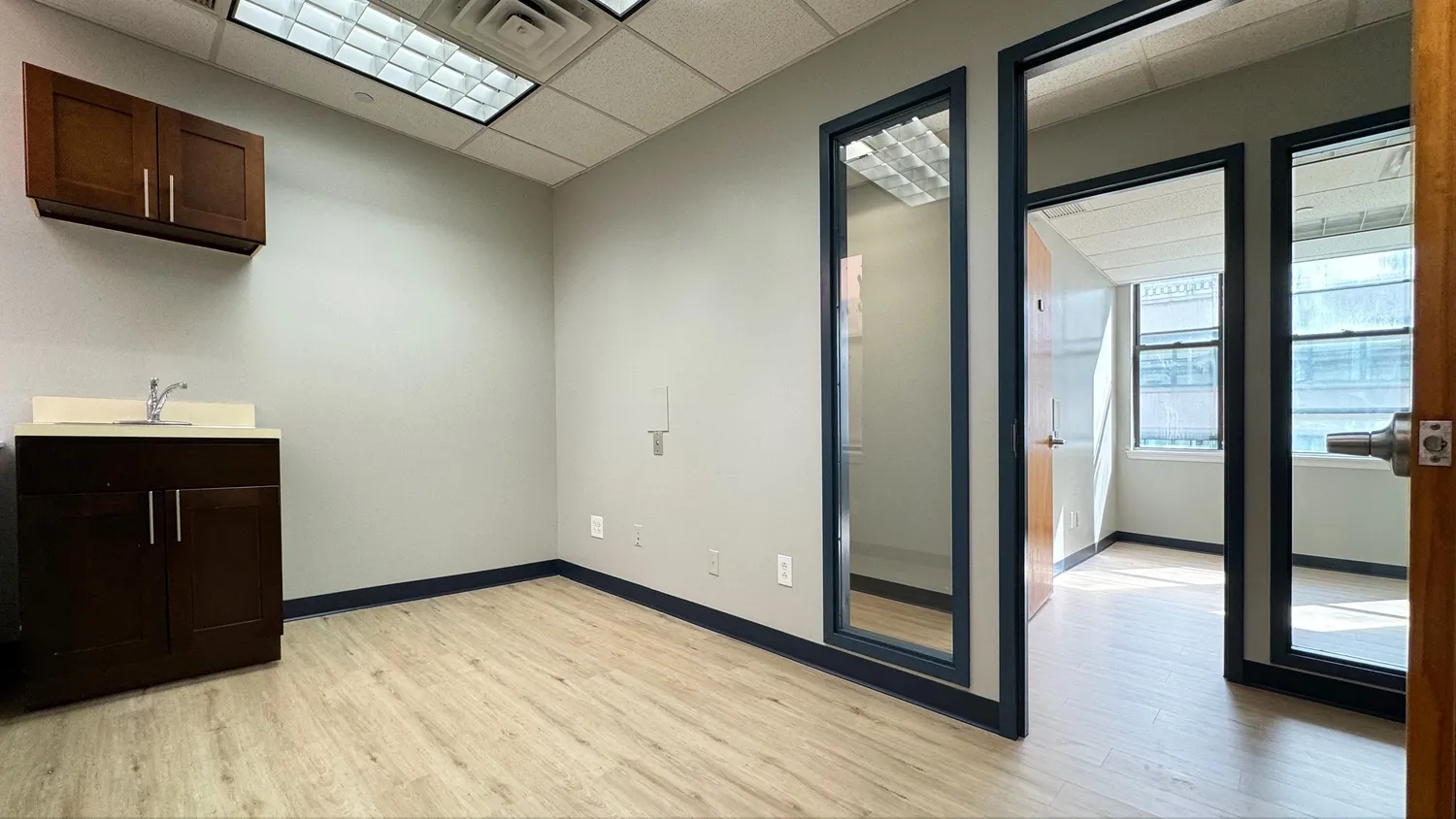 a view of a hallway with wooden floor and cabinet