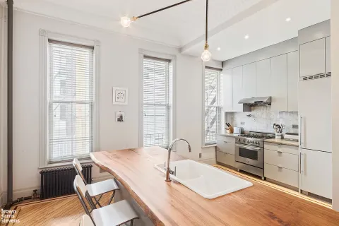 a kitchen with granite countertop a sink appliances cabinets and furniture