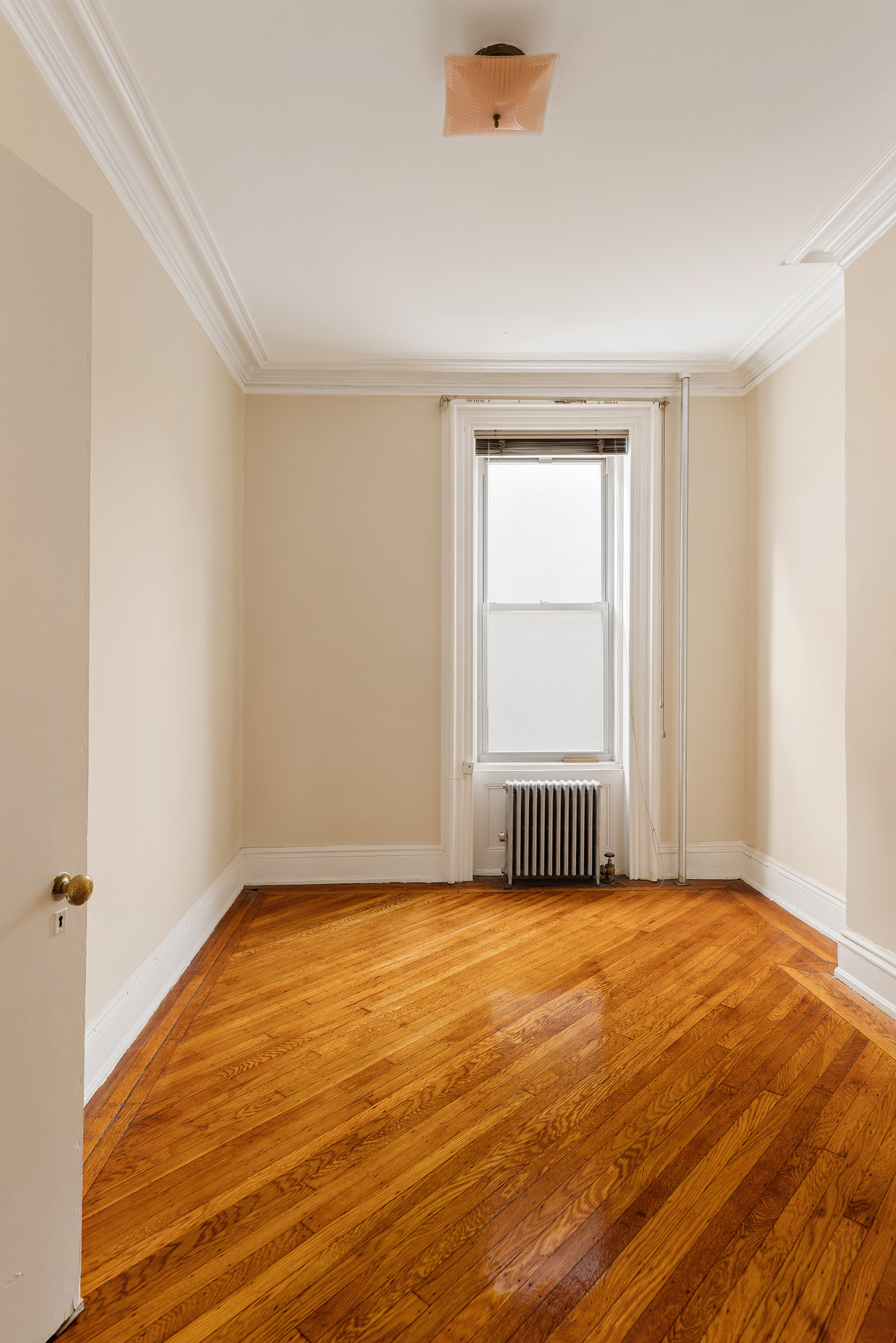 116 Brooklyn Avenue Brooklyn, NY 11216 - Photo 15 of 21 an empty room with wooden floor and windows