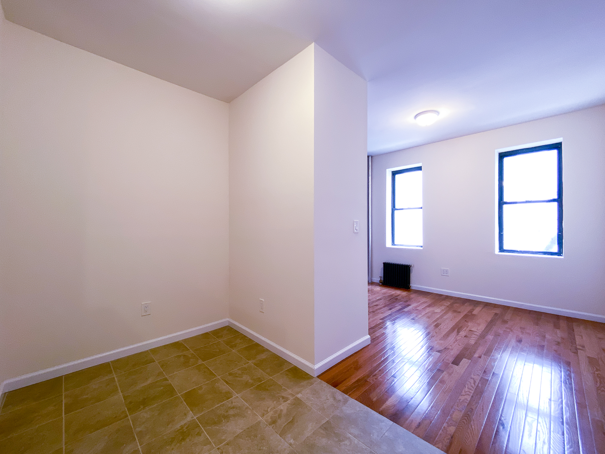 319 East 25th Street, Unit 3C Manhattan, NY 10010 - Photo 2 of 12 an empty room with wooden floor and windows