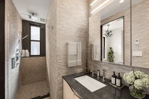 a bathroom with a granite countertop sink a toilet and shower