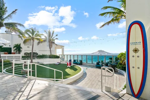 a view of a patio with table and chairs potted plants and palm trees