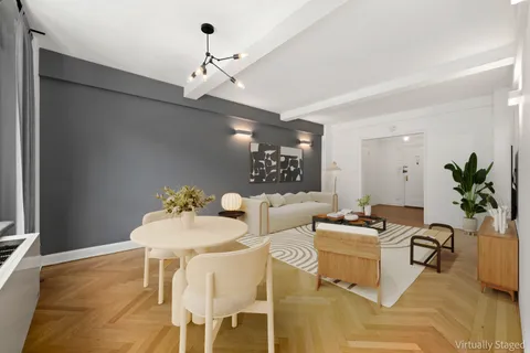 a living room with furniture a chandelier and a rug