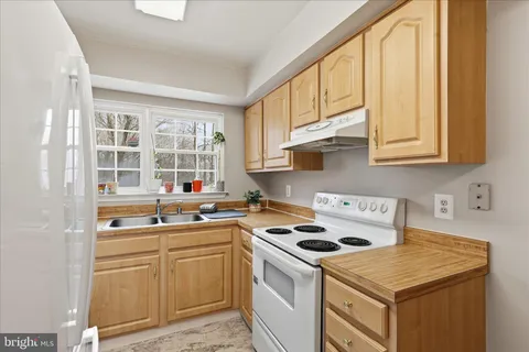 a kitchen with stainless steel appliances granite countertop a sink and a white cabinets