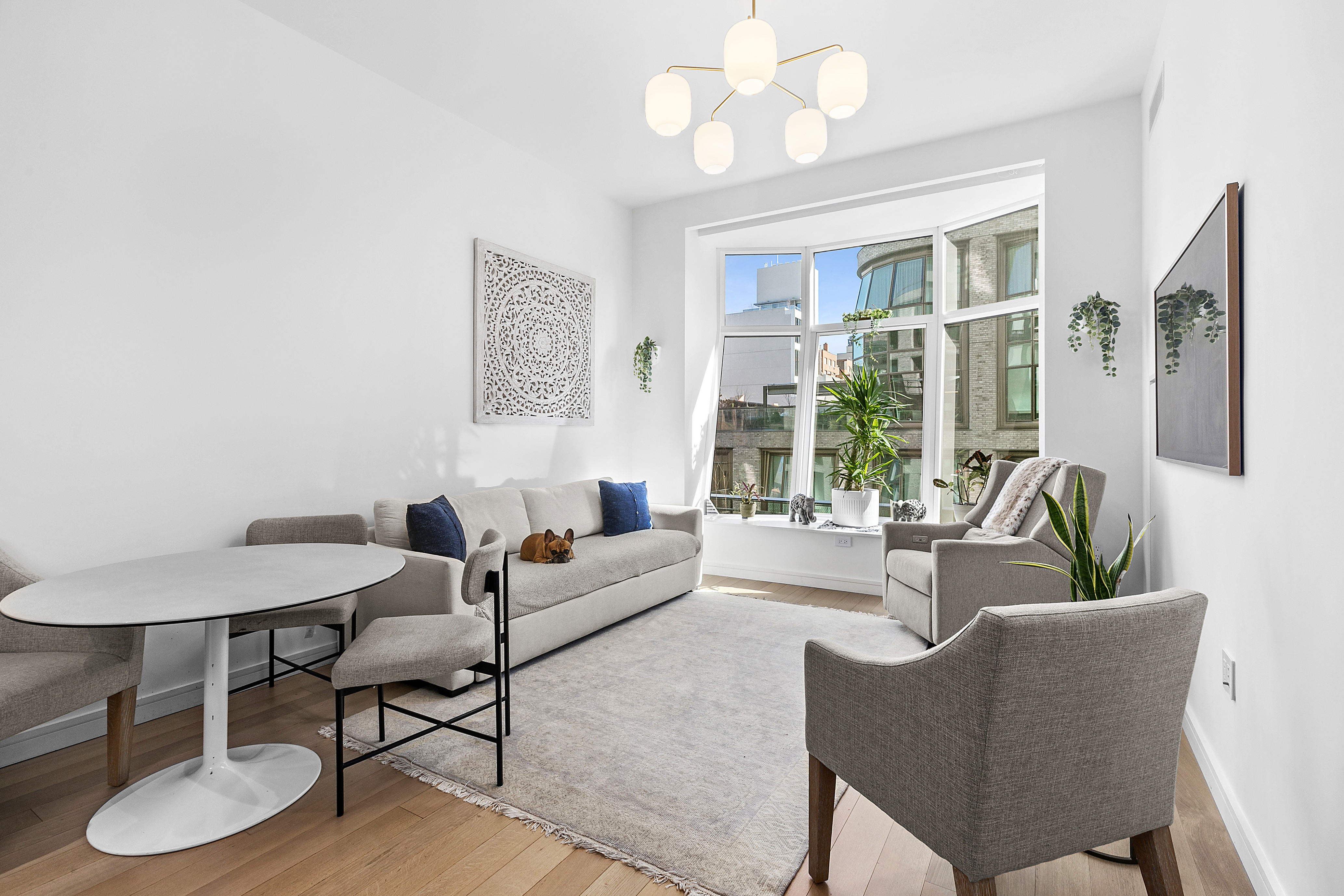 a living room with furniture a chandelier and a window