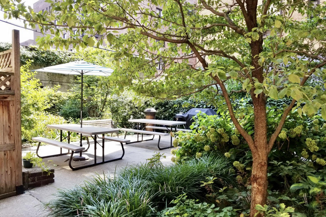 736 West 186th Street, Unit 5B Manhattan, NY 10033 - Photo 9 of 16 a view of a patio with table and chairs under an umbrella with a small yard