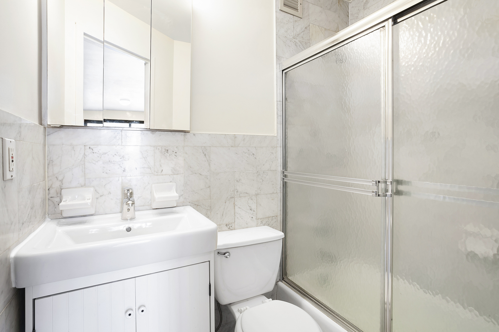 325 West 51st Street, Unit 4C Manhattan, NY 10019 - Photo 4 of 7 a bathroom with a sink a toilet and shower