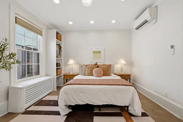 a bedroom with a bed and wooden floor