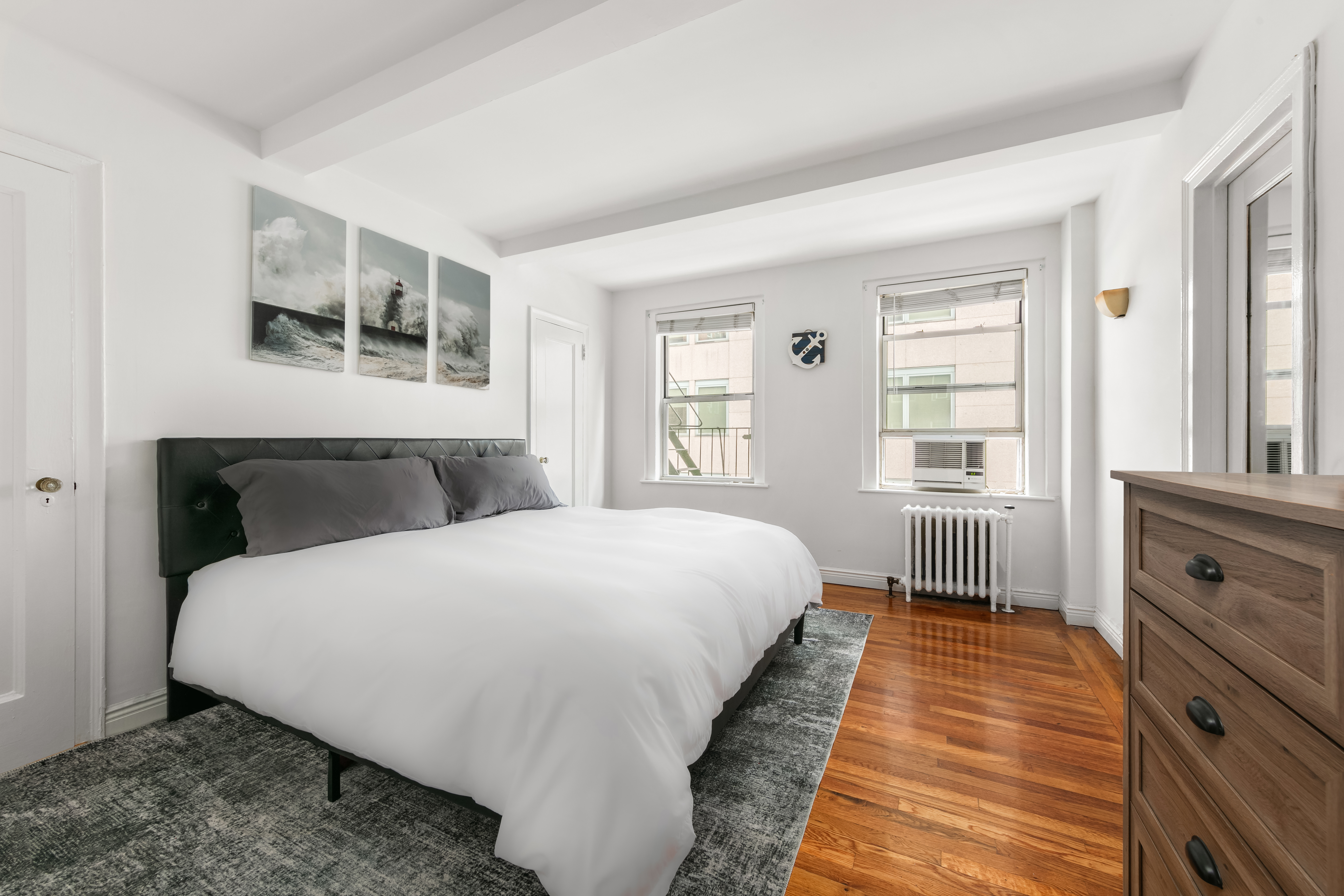 333 East 43rd Street, Unit 709 Manhattan, NY 10017 - Photo 4 of 15 a spacious bedroom with a bed and wooden floor