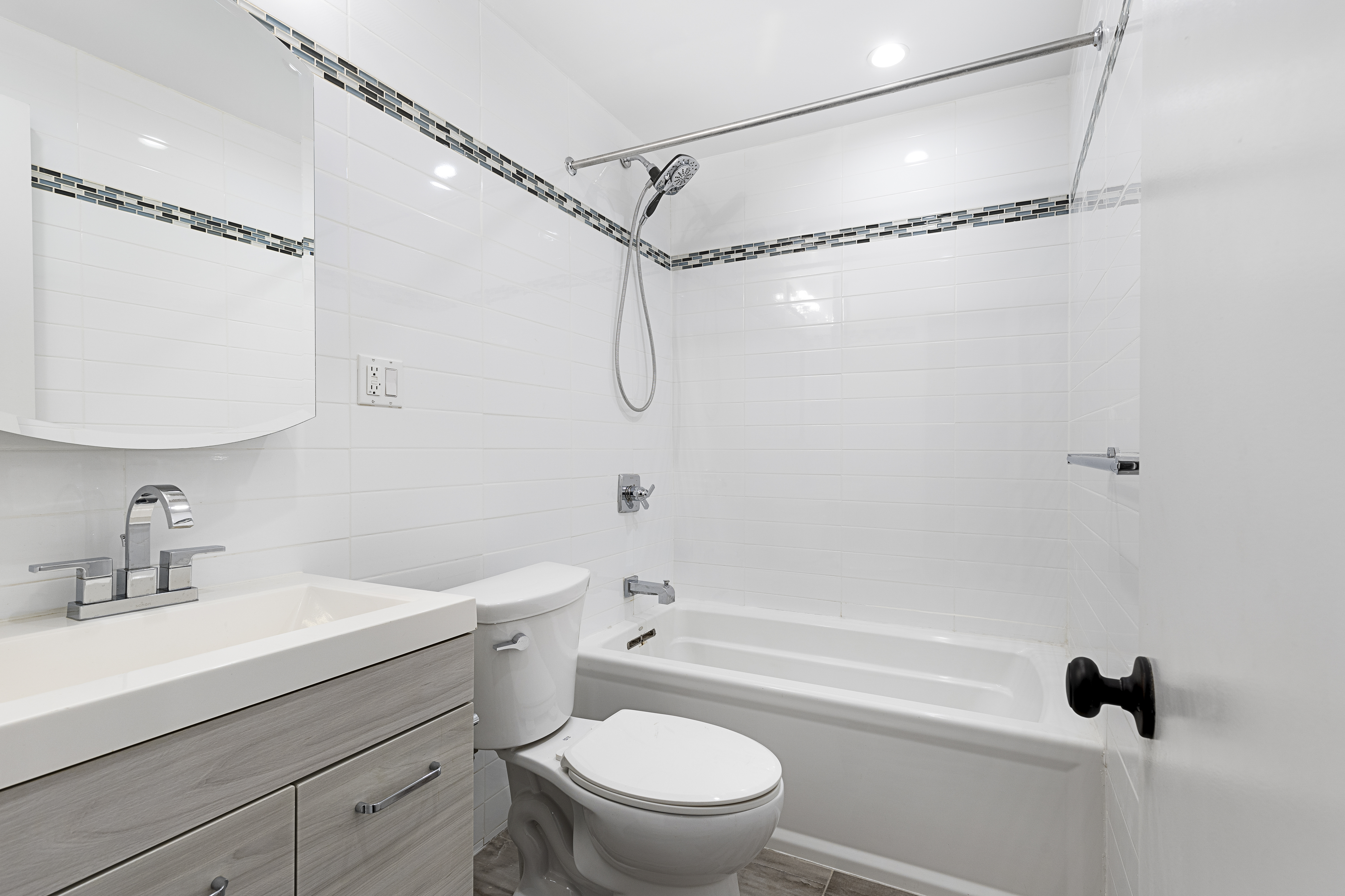 346 West 52nd Street, Unit 4D Manhattan, NY 10019 - Photo 4 of 7 a bathroom with a sink a mirror a toilet and shower