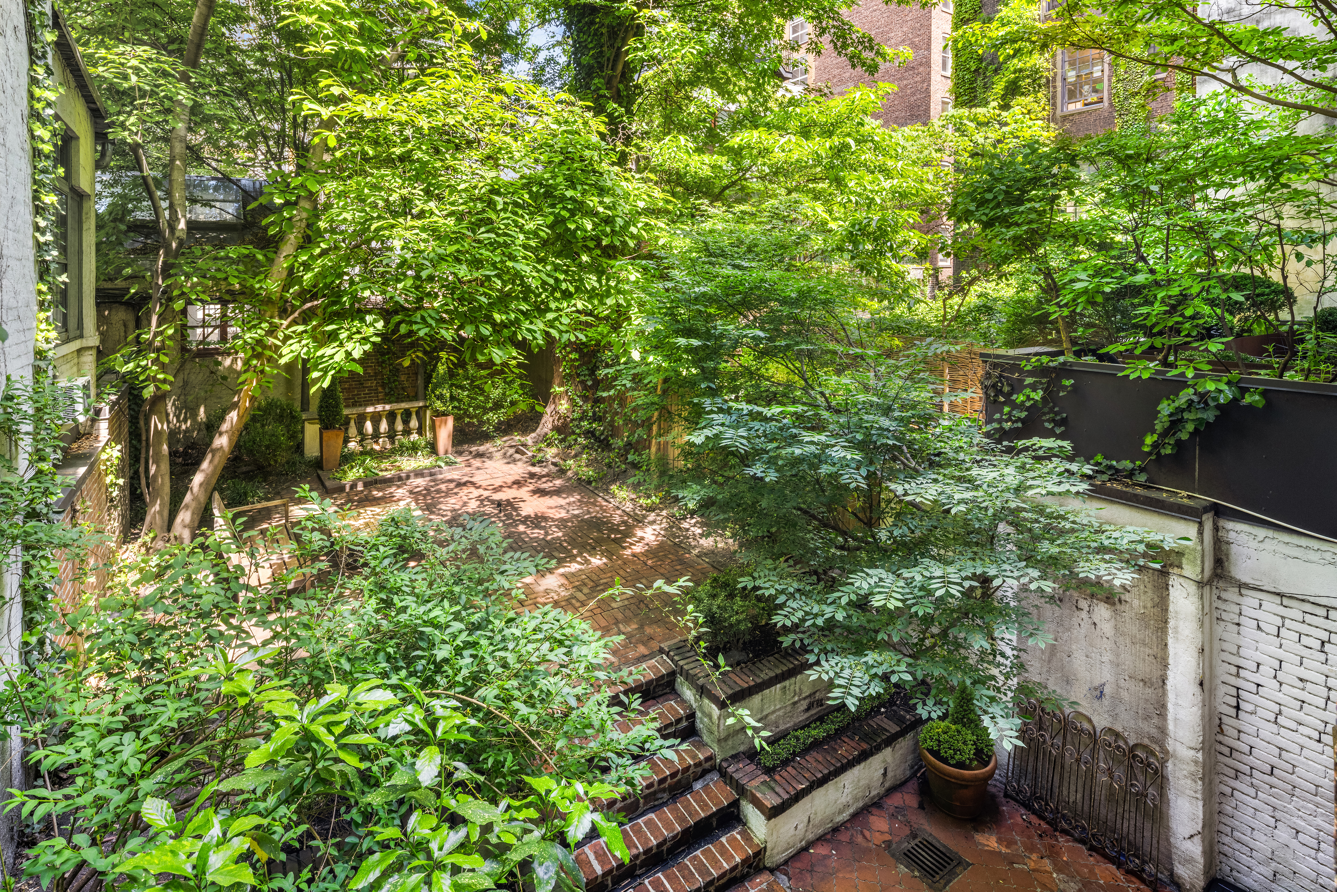 57 West 9th Street Manhattan, NY 10011 - Photo 5 of 11 a backyard of a house with lots of green space and a fountain