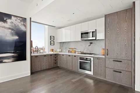 a kitchen with granite countertop white cabinets and stainless steel appliances