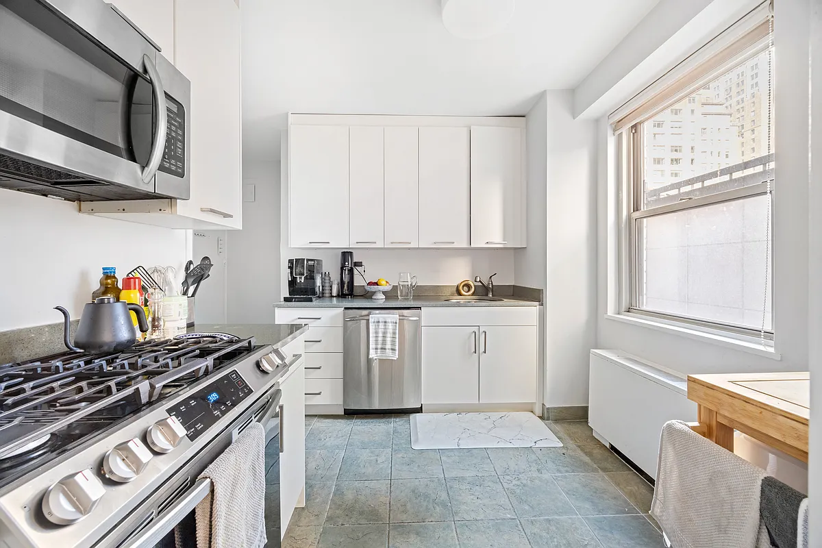 300 East 40th Street, Unit 3J Manhattan, NY 10016 - Photo 2 of 8 a kitchen with stainless steel appliances granite countertop a stove and a sink