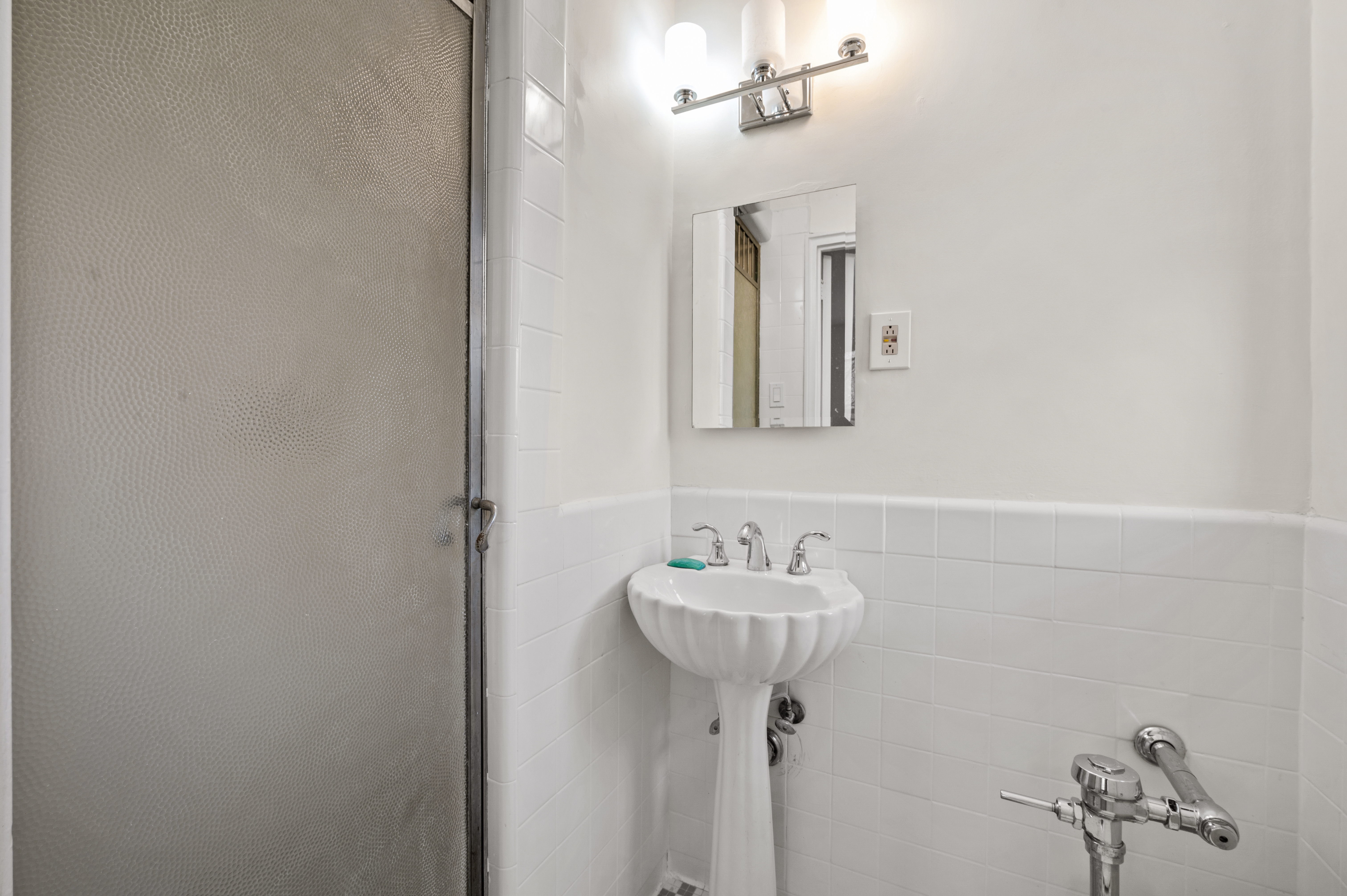 159-34 Riverside Drive West, Unit 3D Manhattan, NY 10032 - Photo 9 of 12 a bathroom with a sink and a mirror