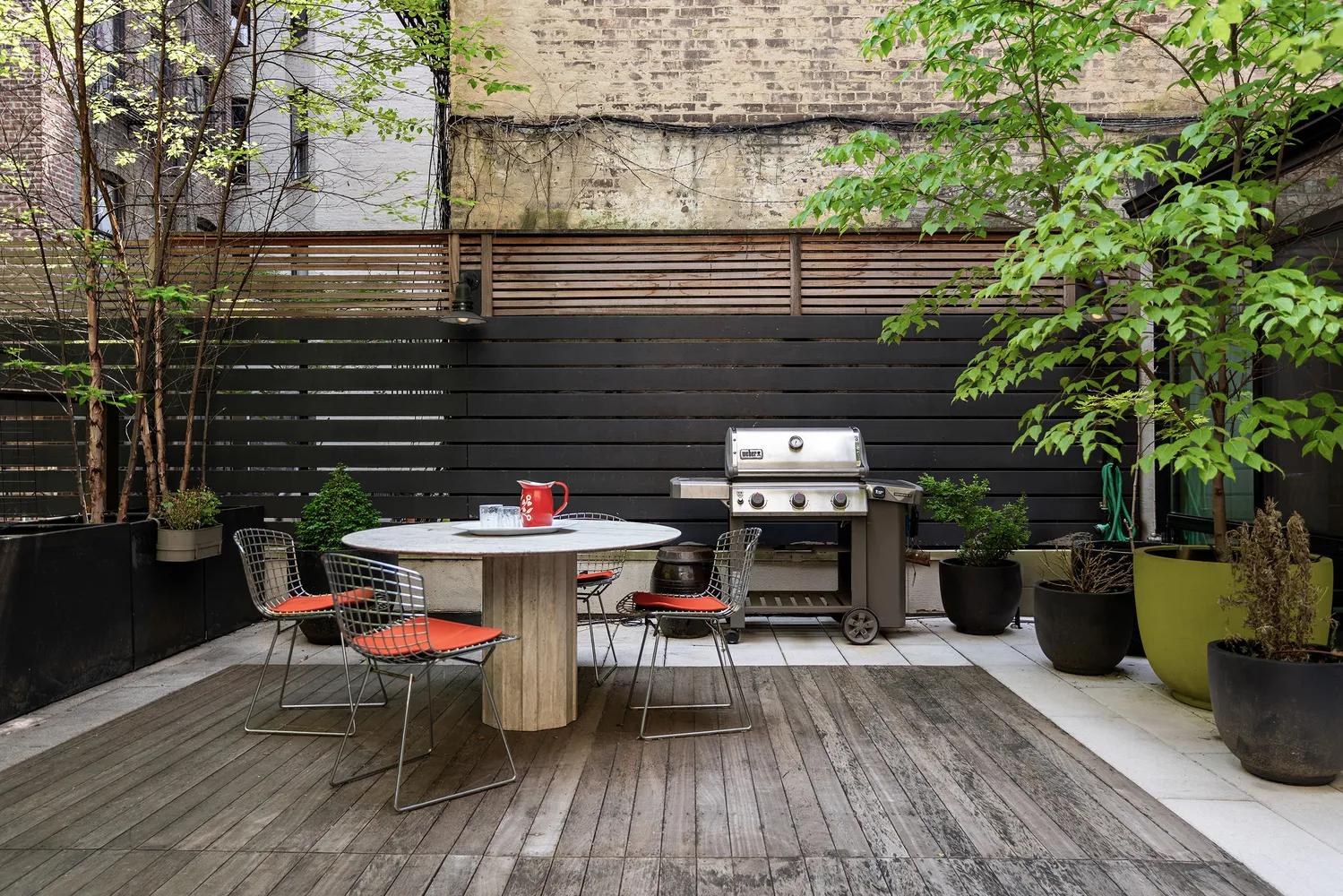 a backyard of a house with dining table and chairs