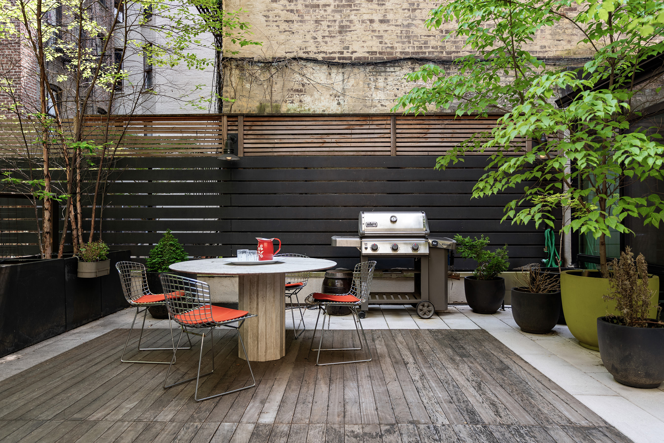 54 MacDougal Street, Unit 1 Manhattan, NY 10012 - Photo 13 of 23 a backyard of a house with dining table and chairs