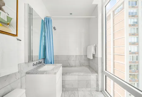 a bathroom with a granite countertop sink a toilet and shower
