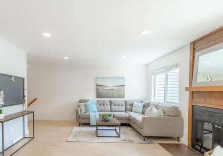 a living room with furniture a fireplace and a flat screen tv