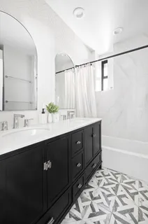 a bathroom with a double vanity sink a mirror and a bathtub