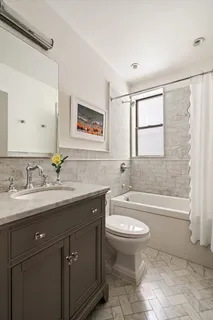 a bathroom with a granite countertop toilet sink and mirror