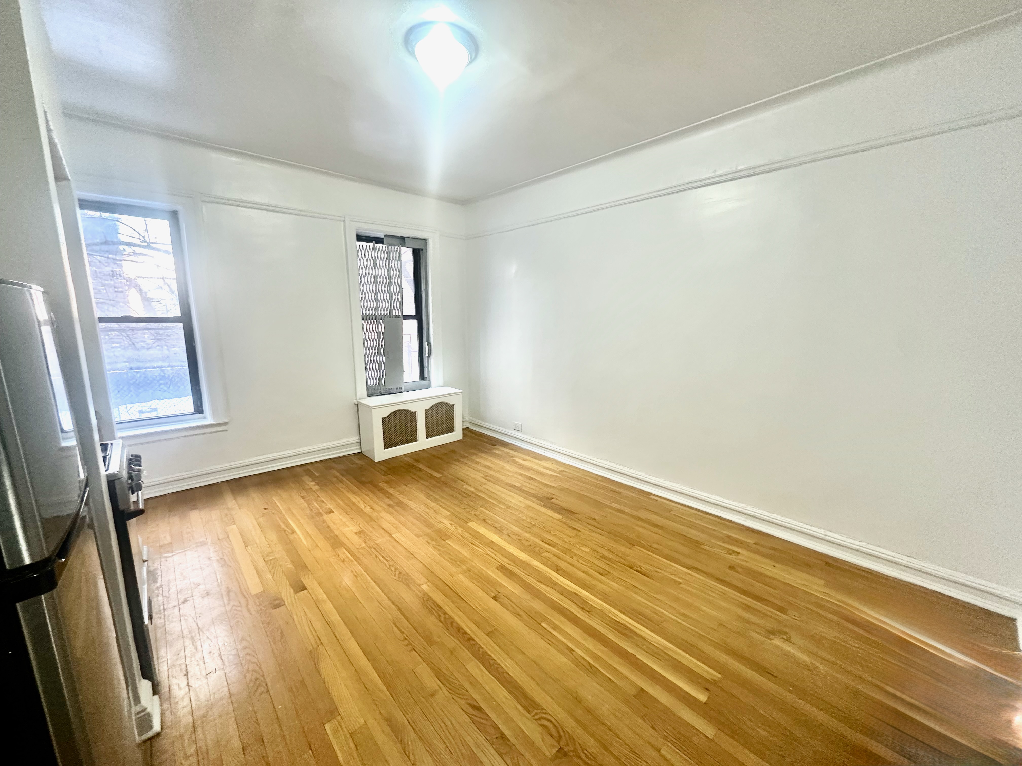 517 West 161st Street, Unit 4 Manhattan, NY 10032 - Photo 2 of 3 an empty room with wooden floor and windows