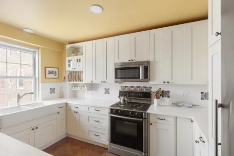 a kitchen with white cabinets and white appliances