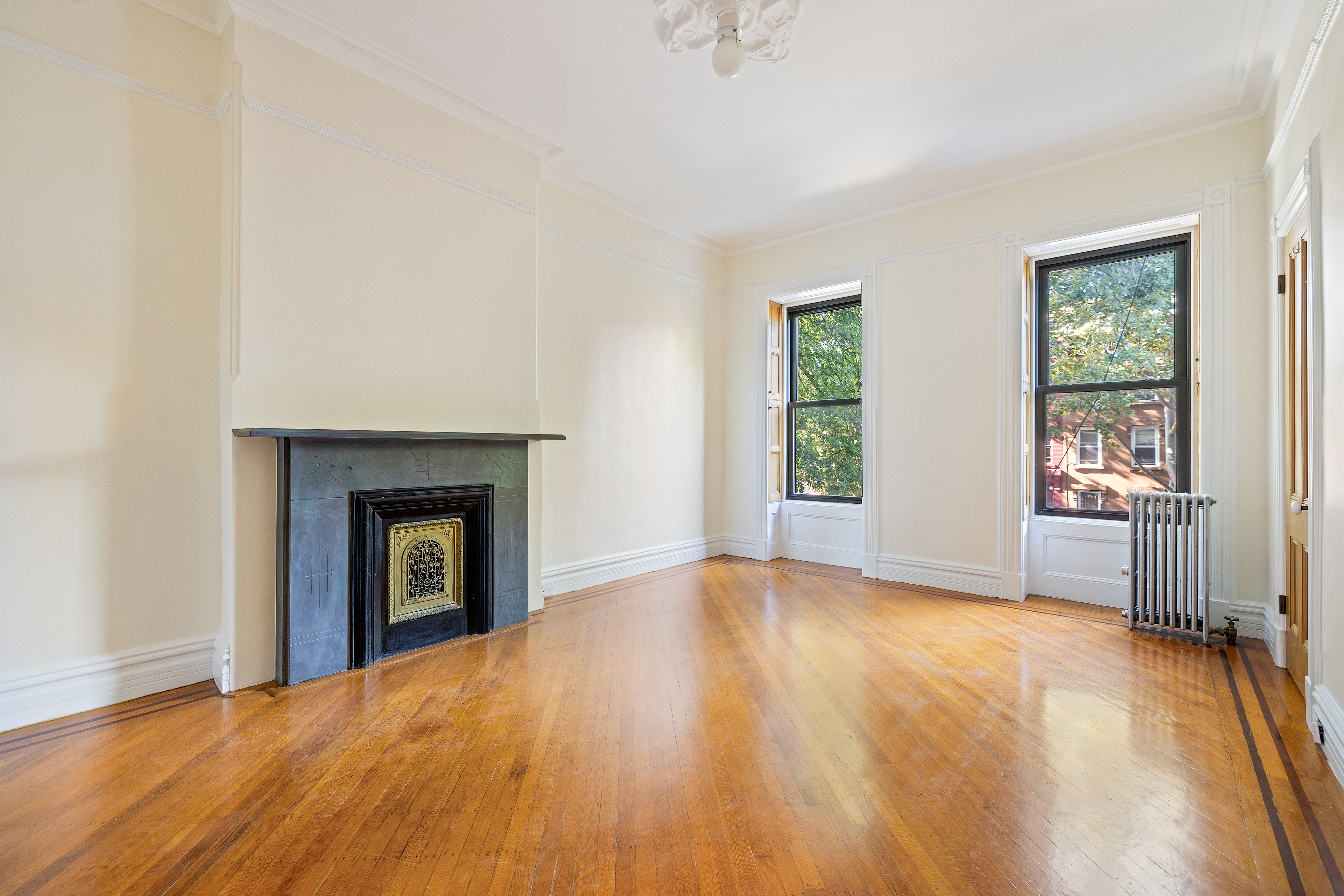 778 Quincy Street, Unit 2 Brooklyn, NY 11221 - Photo 11 of 14 an empty room with windows and a fireplace