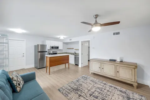 a living room with furniture and kitchen view
