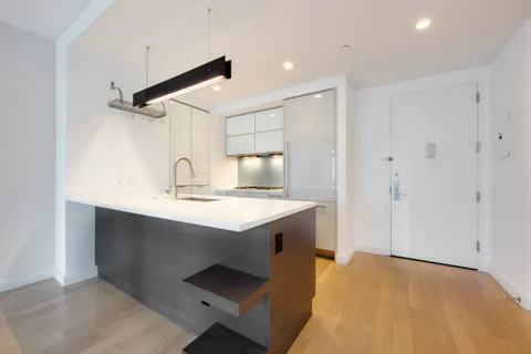 a view of a kitchen with a sink and wooden floor