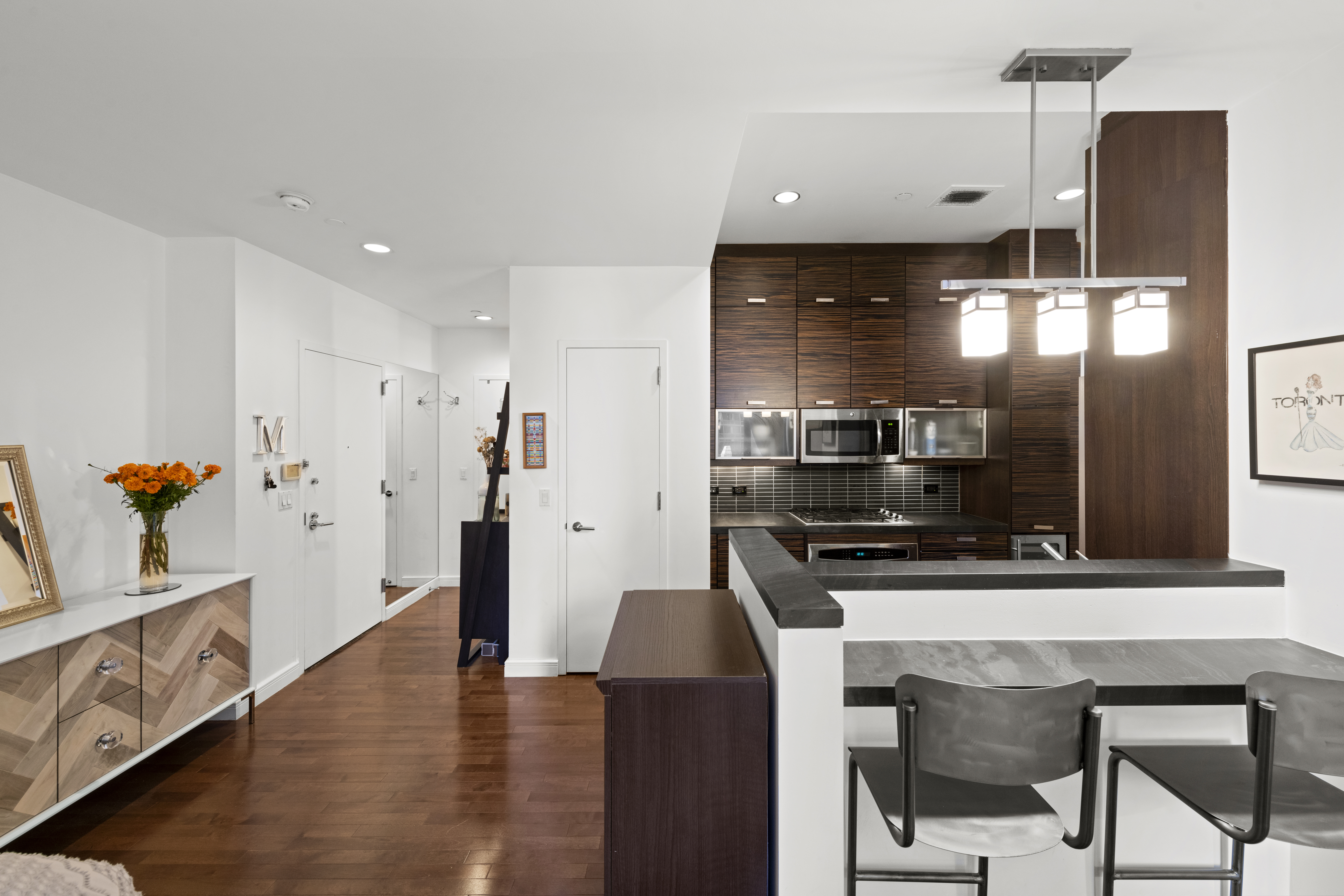101 West 24th Street, Unit 5G Manhattan, NY 10011 - Photo 5 of 16 a kitchen with stainless steel appliances granite countertop a sink a stove and a refrigerator