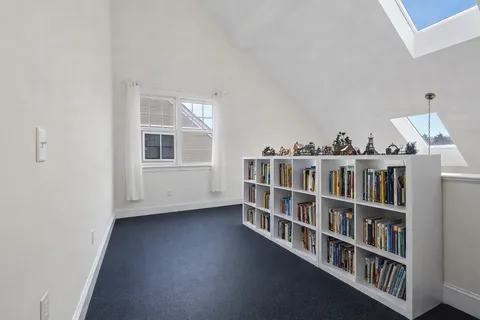 a living room with a book shelf and a book shelf