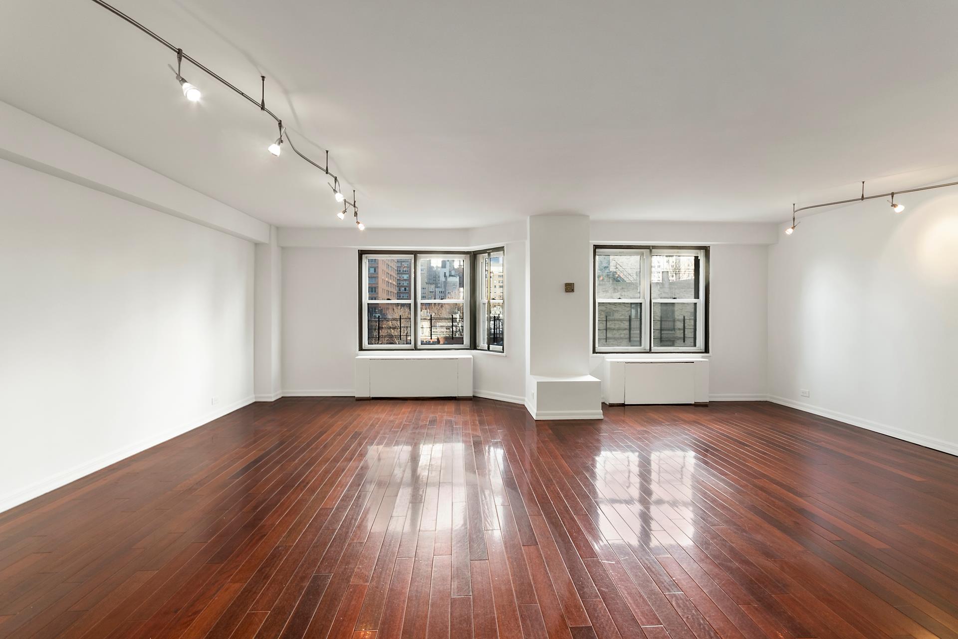 220 East 60th Street, Unit 7CD Manhattan, NY 10022 - Photo 1 of 11 an empty room with wooden floor and windows