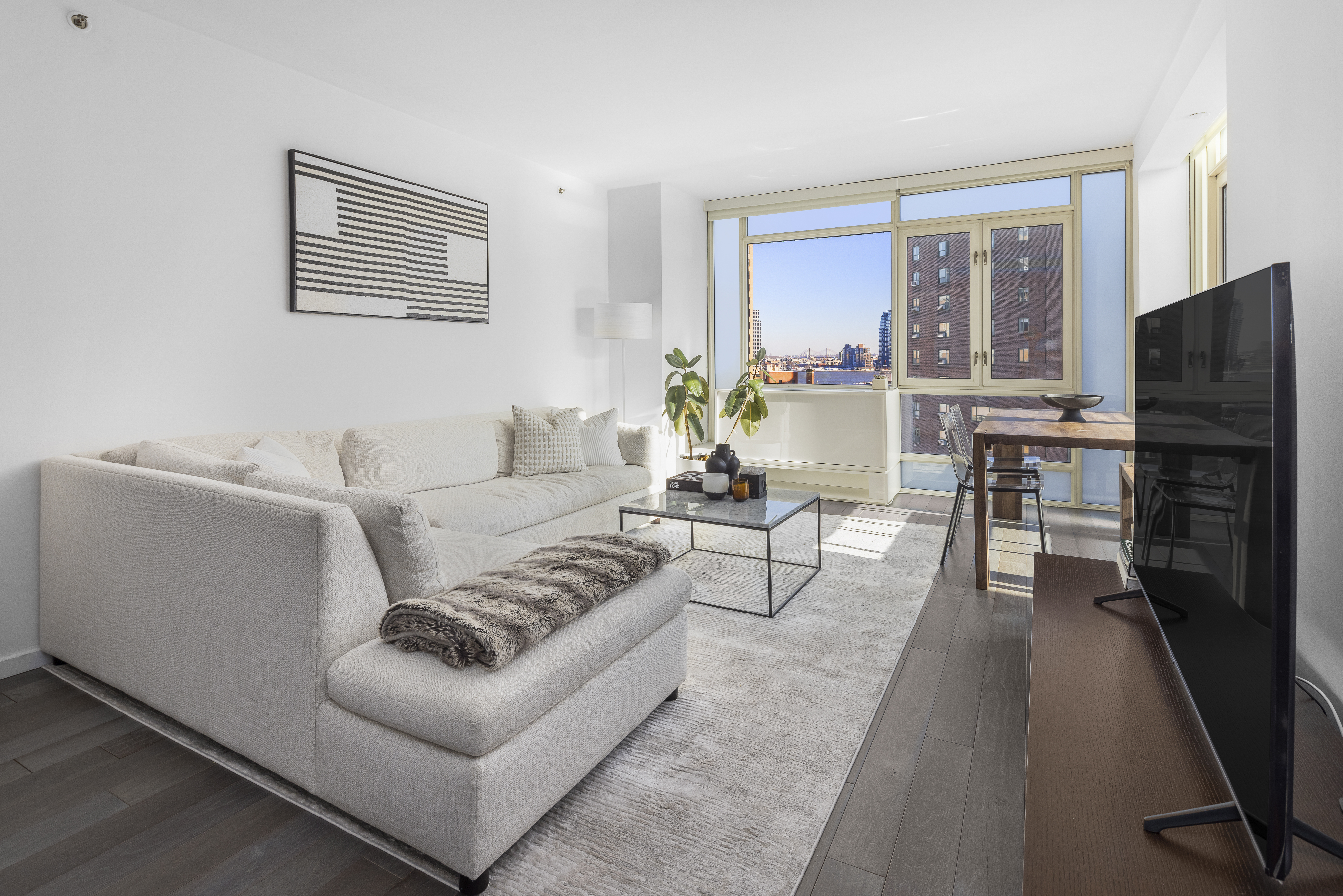 385 1st Avenue, Unit 10G Manhattan, NY 10010 - Photo 5 of 22 a living room with furniture tv and a window
