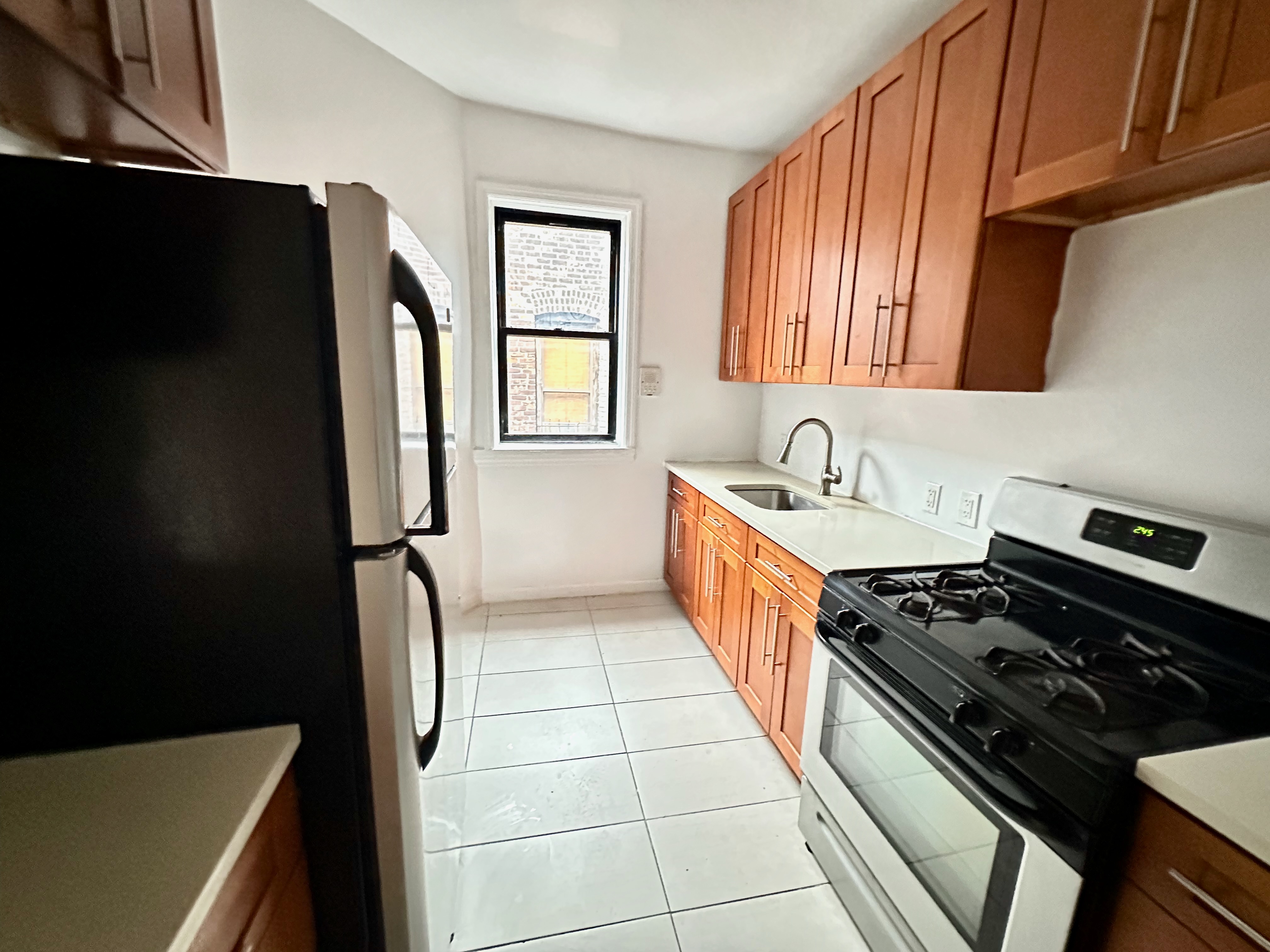541 West 144th Street, Unit 17 Manhattan, NY 10031 - Photo 1 of 6 a kitchen with a refrigerator a sink and a stove