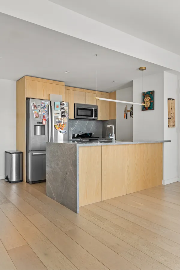 a kitchen with stainless steel appliances a refrigerator sink and microwave