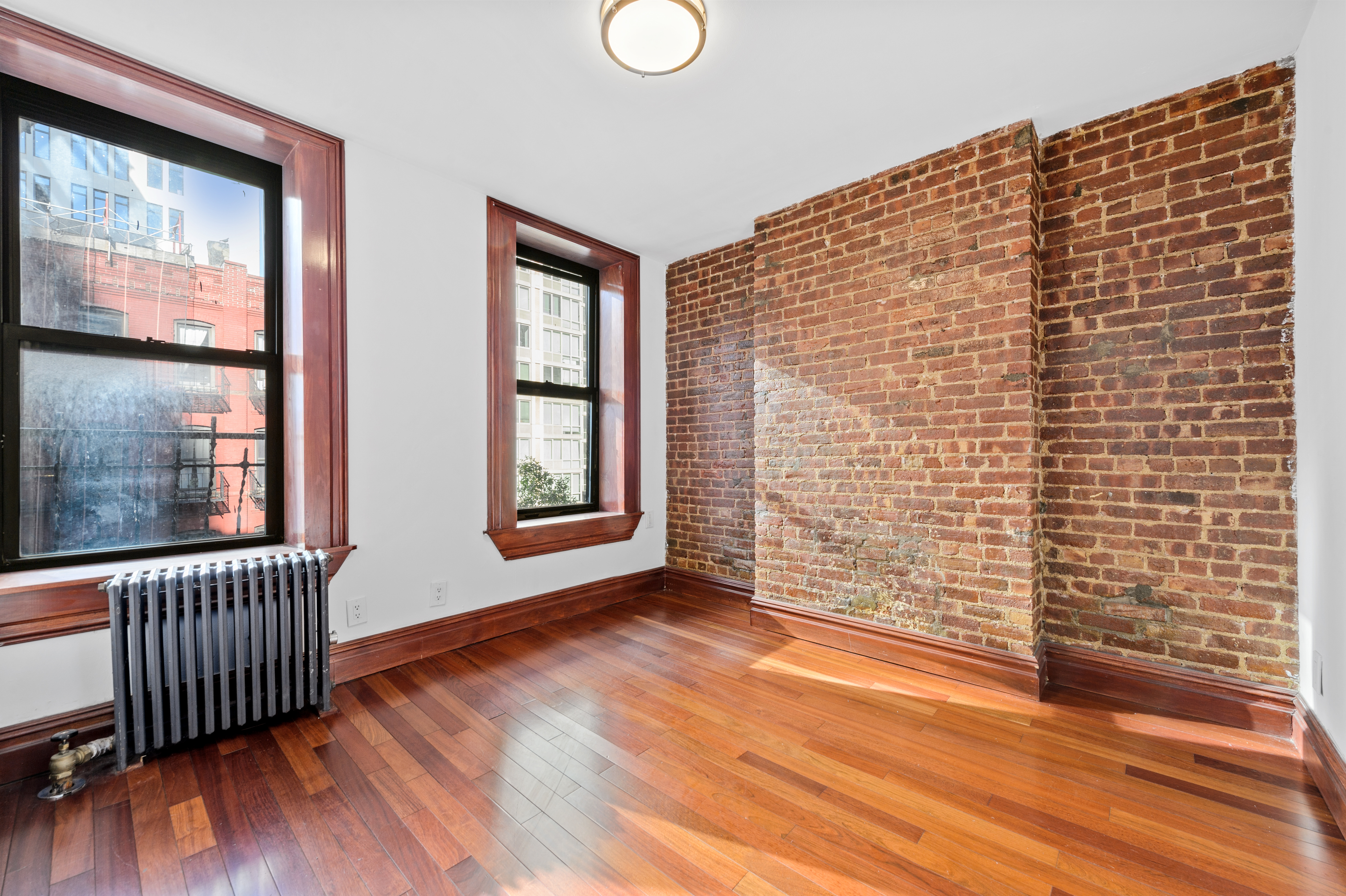 a view of an empty room with glass door and wooden floor
