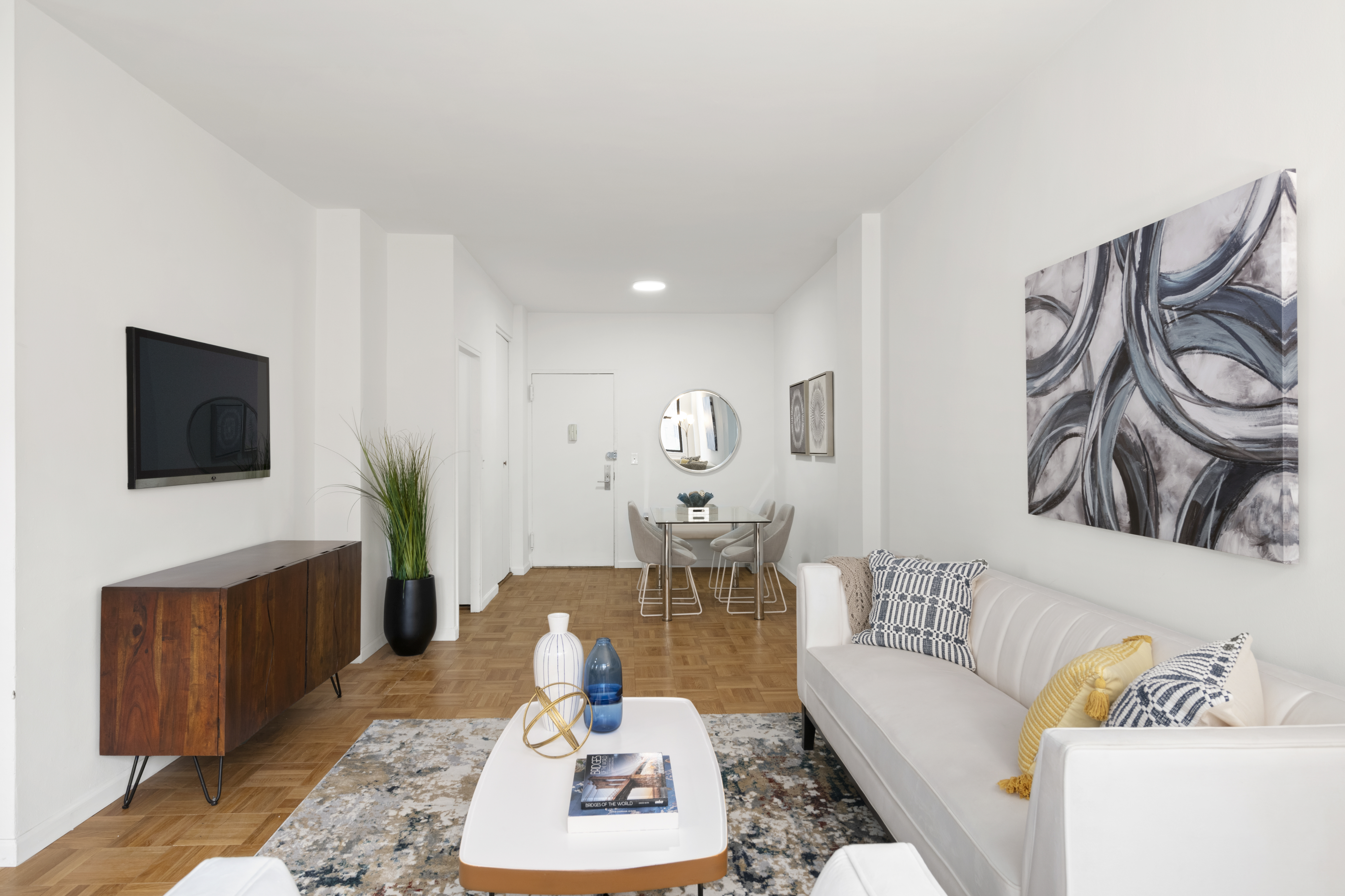 201 East 21st Street, Unit 15C Manhattan, NY 10010 - Photo 2 of 9 a living room with furniture and a flat screen tv