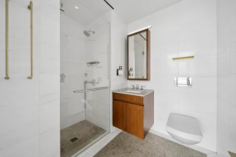 a bathroom with a shower a mirror and a sink